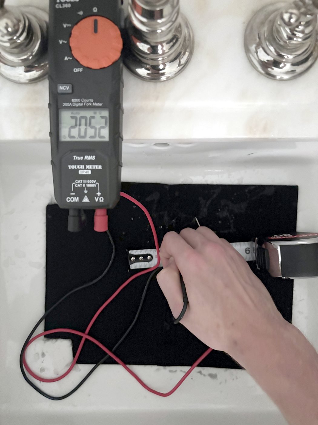 Multimeter reading 2.052 megohms with probes on damp untreated welding blanket